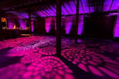 Pattern wash of bright fuchsia on wedding dance floor of barn at Cornerstone Gardens, California.