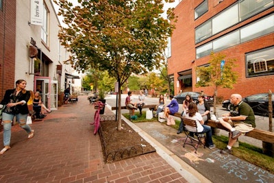 Baked & Wired encouraged interaction by offering chalk for visitors. The parklet's design elements included reclaimed railroad tracks and fresh plants and grass.