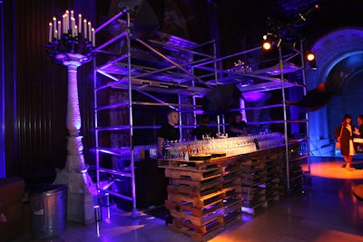 One of the bars for the premiere party was set up directly outside the Edna Barnes Salomon Room. Designed to represent the dark alleys of Gotham—where Bruce Wayne's parents are murdered and where viewers first meet Oswald Cobblepot, also known as the Penguin—the setup included scaffolding, old pallets, metal garbage cans, and acrylic painted to look like junk. Open black umbrellas hung from the scaffolding as a visual cue to the Penguin.