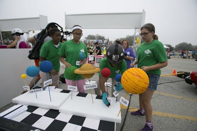 A so-called 'pit row' was set up in the middle of the racecourse. Each time a team completed a lap around the course, its members got out of the car and participated in a group challenge that was related to science, technology, engineering, or math.