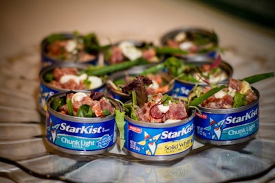 Cuisiniers Catered Cuisine & Events is offering a new twist on the traditional Salad Niçoise. A genuine tuna fish can is filled with a mix of raw yellowfin tuna, haricots verts, imported anchovies, seasonal greens, a quail egg, and olive aioli.