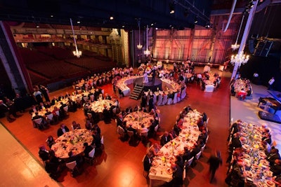 Planners set up tables of different sizes and shapes on the stage at the Wang Theatre.