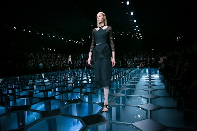 In making the bold decision to host his Balenciaga show at 8 p.m. in lieu of the 9 a.m. time slot the brand has occupied for more than a decade, Alexander Wang also moved the outing's venue from the Observatoire de Paris to the Cité de l'Architecture et du Patrimoine. To reflect the change of energy of the show, a black tent was erected over the empty fountain behind the Palais de Tokyo. The underlit runway became a clear grid reinterpretation of a classical French-tiled floor, with swirling vapors of dry ice visible underneath, complementing the after-dark vibe of the show. OBO co-produced the show with Prodject.