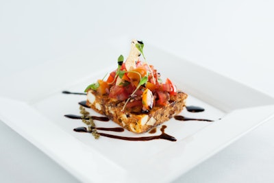 Indian bruschetta with crispy poppadums with paneer, topped with red and yellow tomato chutney, tamarind syrup, and cilantro, by Entertaining Company in Chicago