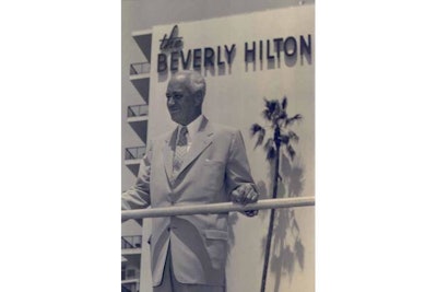Conrad Hilton in front of Beverly Hilton sign
