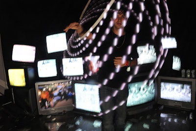 An LED Hula-Hoop provided an interactive art experience in front of an area filled with old TV sets.