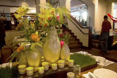 A cluster of oversize porcelain vases filled with flowers and beds of grass formed the centerpiece at Keith Kreeger’s earthy table.