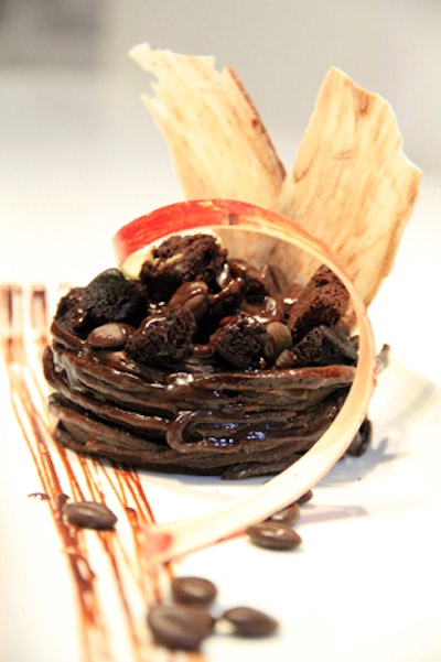 Brownie-flavored pasta formed into a nest, filled with brownie bits and chocolate, and drizzled with caramel sauce, by Encore Catering in Toronto