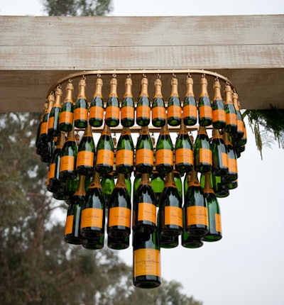 A pair of chandeliers that each incorporated 75 champagne bottles in four different sizes dangled from 12- by 12-foot wooden arches.