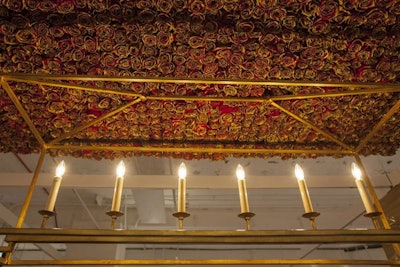 Taking inspiration from the fairy tale Beauty and the Beast, Illinois Institute of Art students created a luxe-looking vignette with a fur table covering, golden goblets, and gold-tinged roses on the ceiling.