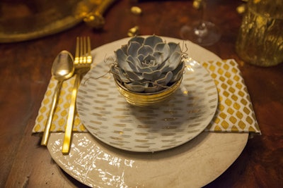 A succulent provided contrast to the opulent gold bowl, glossy place setting, and shiny flatware at the table from the American Society of Interior Designers.