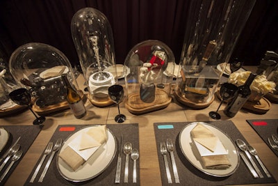 “The tablescape was conceived with a nod to the game Clue and the weapons game pieces,” explained Richard Cassis, principal and creative director of Sparc Inc. The display’s murder mystery dinner theme featured glass cloche vignettes, which contained items such as a replica Civil War revolver balanced on a stack of 8 balls, a sterling silver candlestick atop a set of plates and linens, and an antique wrench hidden in a bouquet of white roses.
