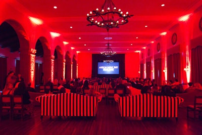 Red lighting bathed striped sofa seating in the screening space.