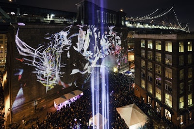 A series of mapping projections designed by artists from around the world and curated by creative collective 3 Search enveloped one side of the base of the Manhattan Bridge while hundreds of attendees filled the surrounding plaza to watch the show.