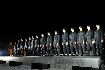 For the finale, 25 dancers clad in black eye masks and skullcaps broke from their formation and swarmed the guests, all the while drawing them toward the survival kit on display. The performance closed with a single spotlight positioned over the product.