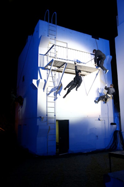 With bright spotlights focused on them, a group of 16 stuntmen scaled the walls, adding further drama.