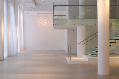Brilliant white brick walls, white drapery and polished concrete floors create an elegant loft aesthetic