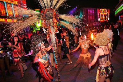 108 costumed dancers, acrobats and aerialists filtered through the event space performing on 5 stages, in the streets and suspended overhead