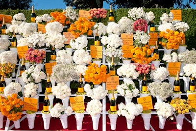 The Veuve Clicquot Polo Classic is known for its whimsical decor done in the brand's signature yellow-orange color. In 2013, the Los Angeles event included a vintage flower-stand-style step-and-repeat. In addition to flowers, bottles were potted like plants and logo plaques on wooden sticks were planted in moss.