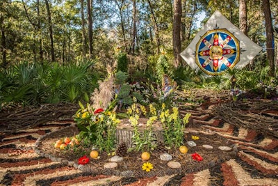 Jeroch Carlson's Natural Mandala Art infused earthy elements including fruits, pinecones, and flowers to create a calming work of art among the woods.