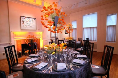 The gray tabletop decor in one of the dining areas of Phillips Collection's 90th anniversary gala provided a striking contrast to the tall orange and yellow floral arrangements by Jack Lucky Floral Designs.