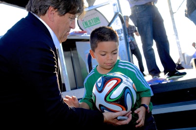 Mexico’s national soccer team coach Miguel Herrera autographs balls for one of his youngest fans.