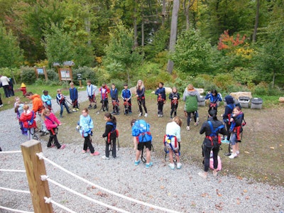 A group of young climbers dons their climbing harnesses