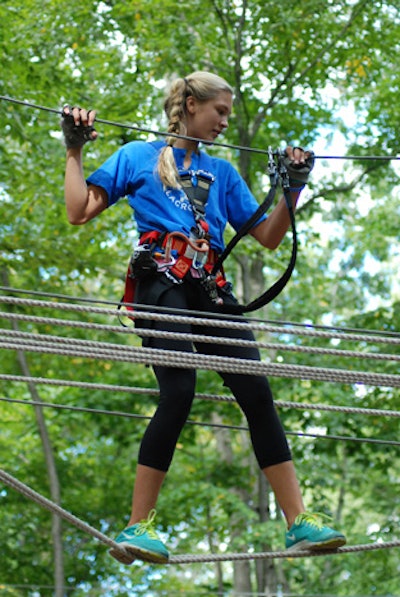 Crossing a rope bridge at The Adventure Park