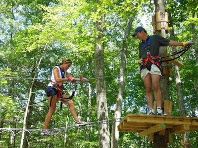 Climbing to a tree platform from an element at The Adventure Park