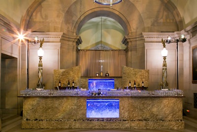 A custom bar was created with textured faux stone and had real stones at the foot. Water features—normally not allowed in the venue—were contained with Plexiglas.