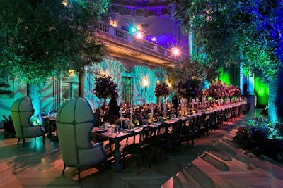 The dining space was surrounded by four living trees as well as projections of trees to create a forest-like atmosphere. The lush flowers from Amaryllis included a mix of high and low arrangements along the length of the table.