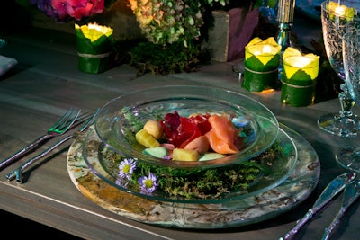 The first course from Occasions Caterers was served on clear dishes with moss, flowers, and pine needles nestled in between the bowl and the plate, reinforcing the room's forest-like decor. The flatware resembled twigs.