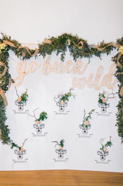 A swath of ribbon-tied greenery from the Hidden Garden hung over Tassels and Tastemakers' cheeky, flower-accented photo booth backdrop, designed by the Venue Report. Flipbooth provided the photo booth.