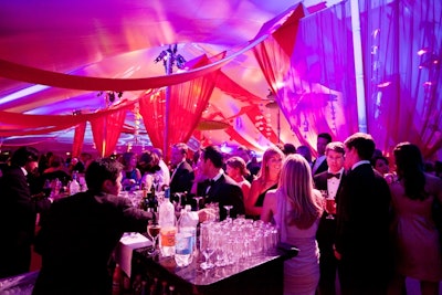 Gala guests mingle, enjoy cocktails and dance under a lit up tent