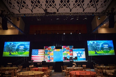 The staging stayed the same for events held in a convention center ballroom, but the seating expanded and contracted depending on the size of an event, from a lunch for 2,800 guests to a breakfast for 500.