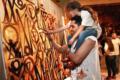During the cocktail reception, the street artist Retna painted works live alongside kids, many of whom were from local community programs.