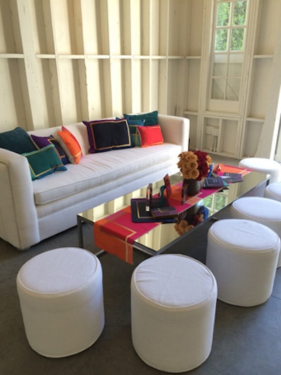 Another of the wedding trends represented at the Mindy Weiss and Wedding Paper Divas event was color blocking. A white seating area demonstrated the look with jewel-toned pillows, and a vibrant runner topping a mirrored table.