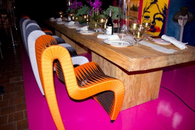 Interior designer Marc Blackwell created a vignette with the message, 'Compassion Begets Art,' in honor of Diffa's mission. The dining table included structural curved chairs with woven fabric in different colors.