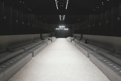 Tom Ford's fall 2015 debut Los Angeles fashion show took place on February 20 at Milk Studios—unofficially kicking off the 2015 Oscar weekend. The 420 guests at the highly exclusive affair were invited to a completely customized show venue that featured gray custom perimeter walls, black smoke-out stretched fabric covering the ceiling, and a lush white carpet over the theater floor. An edgy 30- by 14-foot mirrored backdrop, also reminiscent of the designer's days at Gucci, added extra drama to the event