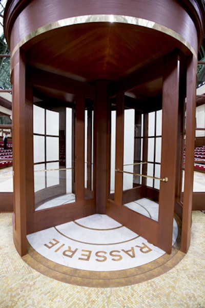 For an added touch of authenticity, guests had to pass through a solidly built, brasserie-style revolving door, beneath a red awning proclaiming Brasserie Gabrielle, to gain entrance to the show space. Models also emerged onto the runway through the revolving restaurant door.