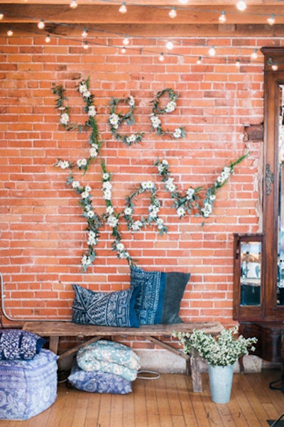 A floral sign on the Tassels and Tastemakers wall, created by Beth Helmstetter, spelled out “Yee Haw” with flowers from Art With Nature.