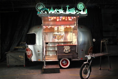 To help Los Angeles’s Pacific Park expand its retail operations, Timeless Travel Trailers created a pop-up installation by converting a 16-foot trailer into a Route 66-inspired retail space. Inside, Timeless used upcycled gas pump shelving units, suitcase drawers, ceiling lights made from old tail lights, and other details. Outside, the company designed and built all of the fixtures using old car parts: a three-tiered shelf made of hoods, an Airstream-theme cash wrap, and a hanging display using a motorcycle fork.