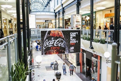 A banner in Circle Centre Mall in downtown Indianapolis encouraged guests to try Coke Zero. Also in the mall, guests could Shazam an ad in a kiosk that made their phones look like a straw they could use to “drink” the liquid on screen. Once the bottle was empty, a coupon appeared for a free Coke Zero at a mall vending machine.
