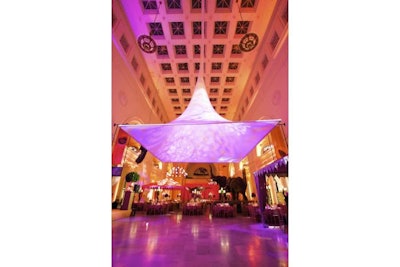 A fabric overhang above a dance floor bathed in light at the Field Museum for an exotic gala