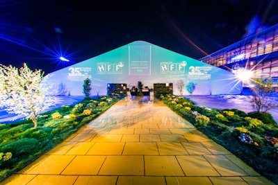 A yellow-brick-road-style entrance, lined with greenery, led guests to the space where the Emerald City ball was held.