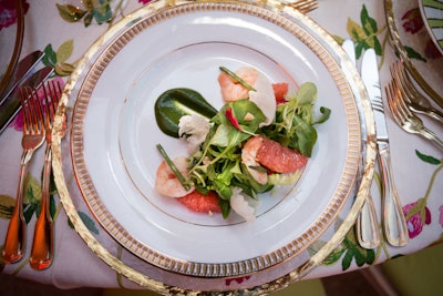 For the first course of the meal, Occasions Caterers served sake-poached gulf shrimp with cashews, grapefruit, and mache accompanied by a watercress emulsion.