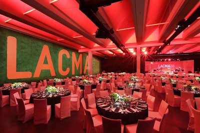 About 750 guests attended the dinner. In the dining area, black fabric draped the east and west walls, while the south wall was an 88- by 22-foot custom green hedge wall installation highlighting the Lacma 50 logo.