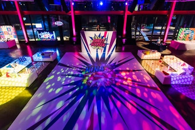 A DJ spun in front of a dance floor that featured the birthday girl’s personal logo at a sweet sixteen party produced by Magnolia Bluebird Design & Events. Warhol-style graphics, props, custom throw pillows, and comic-art-inspired decor punched up the white lounge furniture at the Musikfest Café at the SteelStacks in Bethlehem, Pennsylvania.