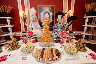 Modern-style shelving and tables displayed silver trays piled high with French macrons, petit fours, and traditional crouqembouche.