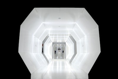 The cocktail portion of the evening featured a series of interconnected all-white rooms, which guests entered into via an octagonal-shaped tunnel. A 32-foot-long walkway led from the spaceship-cum-cocktail area to the dinner space, which was styled to look like the surface of the moon.